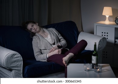 Young Sad Woman Drinking Wine Alone In The Evening