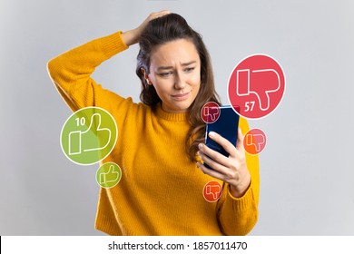 Young sad woman feeling unhappy and desperate holding mobile phone looking more dislikes than likes on her internet social media post in influencer obsession - Powered by Shutterstock