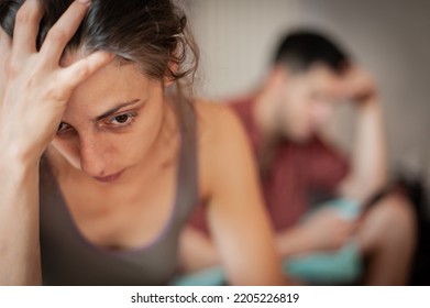 A Young Sad Woman Is Next To Her Partner Who Is Texting On The Phone With Someone, And Not Paying Attention To Her.