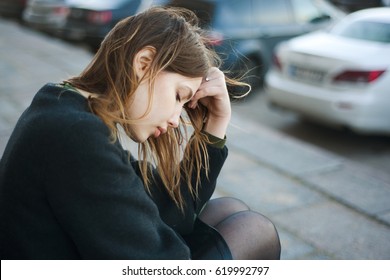 Young Sad Woman Sitting On The Stairs In The Street