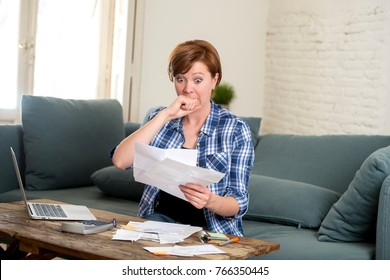 Young Sad Worried And Desperate Woman Banking And Accounting Home Monthly And Credit Card Expenses With Computer Laptop Doing  Paperwork In Living Cost Stress And Paying Bills Problem