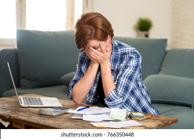 Young Sad Worried And Desperate Woman Banking And Accounting Home Monthly And Credit Card Expenses With Computer Laptop Doing  Paperwork In Living Cost Stress And Paying Bills Problem