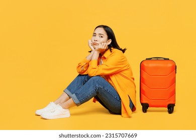 Young sad worried upset woman wear summer casual clothes sit near suitcase isolated on plain yellow background. Tourist travel abroad in free spare time rest getaway. Air flight trip journey concept - Powered by Shutterstock