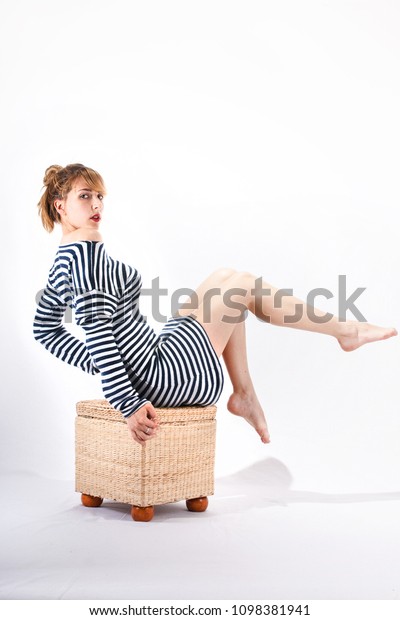 Young sailor\
woman isolated on white background sitting, model posing, studio\
shoot, sailor skirt, marine\
theme