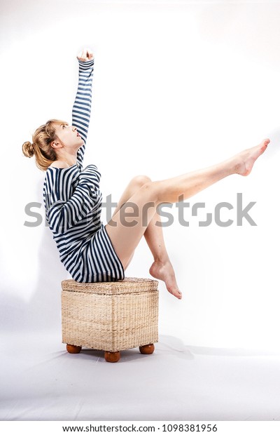 Young sailor\
woman isolated on white background sitting, model posing, studio\
shoot, sailor skirt, marine\
theme