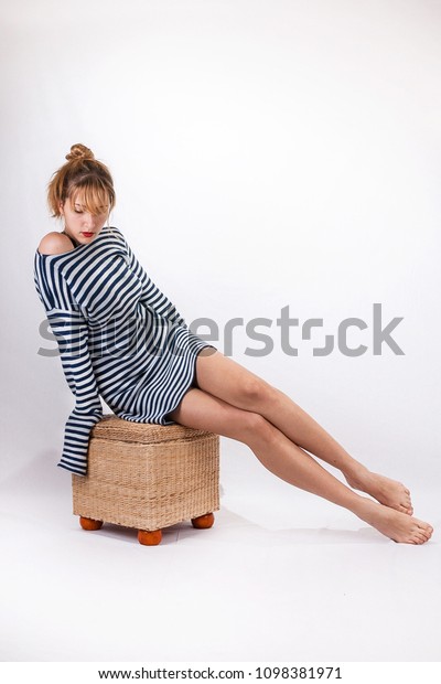 Young sailor
woman isolated on white background sitting, model posing, studio
shoot, sailor skirt, marine
theme