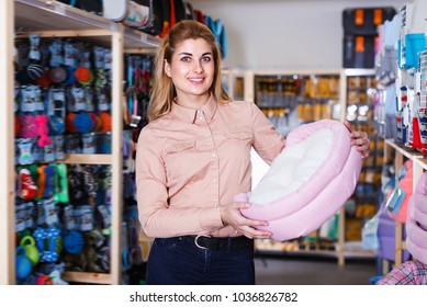 Young Saleswoman Offering Pet Bed In Pet Store