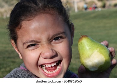 Young Samoan Mixed Girl Outside At Park Eating A Pear