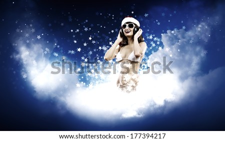 Young Santa girl in white bikini and headphones