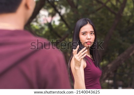 A young sarcastic woman pointing a finger to someone. Joking about having a relationship with the person.