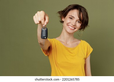 Young satisfied smiling cheerful fun happy woman she 20s wear yellow t-shirt hold in hand give car key fob keyless system isolated on plain olive green khaki background studio People lifestyle concept - Powered by Shutterstock