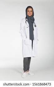 Young Saudi Female Doctor Wearing Doctor Uniform And Hijab And Stethoscope In Various Positions, Expresseions And Hand Gestures On White Isolated Background.