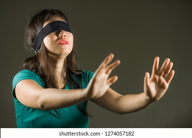 Young Scared And Blindfolded Asian Chinese Teenager Girl Lost And Confused Playing Dangerous Internet Viral Challenge Isolated On Dark Background Under Edgy And Dramatic Studio Light