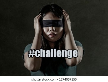 Young Scared And Blindfolded Asian Korean Teenager Girl Lost And Confused Playing Dangerous Internet Viral Challenge Isolated On Dark Background Under Edgy And Dramatic Studio Light