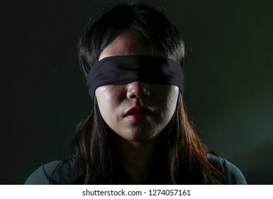 Young Scared And Blindfolded Asian Korean Teenager Girl Lost And Confused Playing Dangerous Internet Viral Challenge Isolated On Dark Background Under Edgy And Dramatic Studio Light