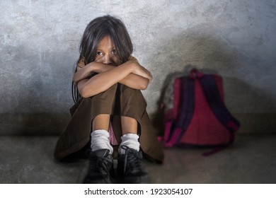 Young Scared And Helpless 7 Or 8 Years Old Female Child In School Uniform Suffering Discrimination And Harassment At School Sitting On Floor Crying In Bullying Problem Concept