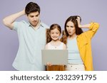Young scared IT parents mom dad with child kid daughter girl 6 years old wearing blue yellow casual clothes hold use work on laptop pc computer isolated on plain purple background. Family day concept