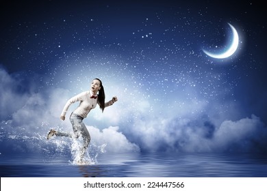 Young Scared Woman Running At Night Under Moon Light