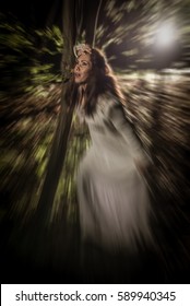 Young Scared Woman Walking Through The Forest At Night In White Dress And Screaming. 