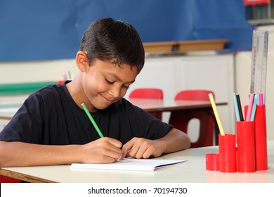 Young school boy age ten writing at his classroom desk