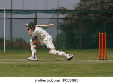 A young school boy is playing a square drive shot with a beautiful follow through finishing it perfectly. - Powered by Shutterstock