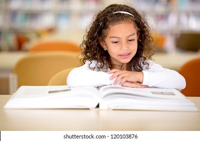 Young school girl reading a book at the library - Powered by Shutterstock