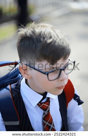 Young Schoolboy Wearing Glasses and Backpack, Ready for School, Outdoors on a Sunny Day