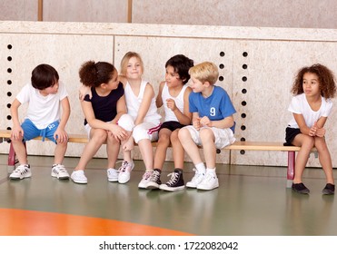 Young schoolchildren sitting on bench in gym - Powered by Shutterstock