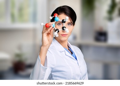 A Young Scientist Looking At A Molecular Structure Model.