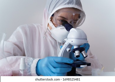 Young scientist looking through a microscope in a laboratory. Young scientist doing some research.