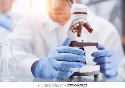 Young scientist looking through a microscope in a laboratory. Young scientist doing some research.
