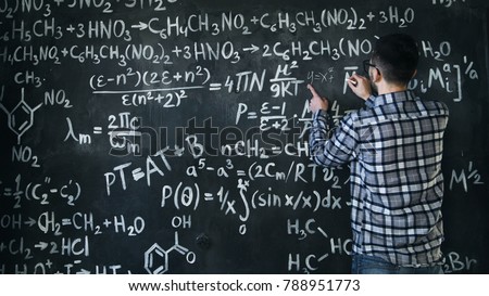 Young scientist man write chock in chemical and mathematical equations wall room interior