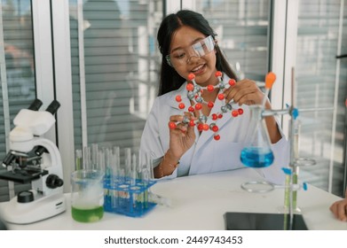 Young scientist studying a molecular structure model in a contemporary laboratory environment. - Powered by Shutterstock