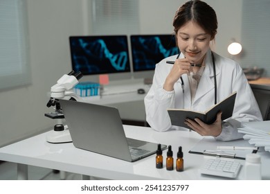 Young scientist taking notes while analyzing a dna structure displayed on a computer screen in a modern laboratory, surrounded by scientific equipment and essential oils