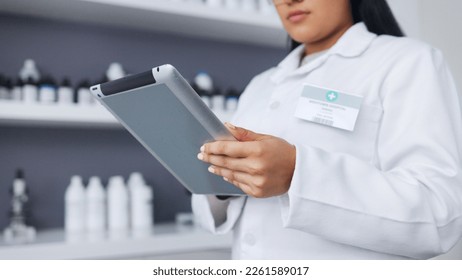 Young scientist using a digital tablet and microscope in a lab. Female pathologist analyzing medical samples while doing experiments to develop a cure. Microbiologist conducting forensic research