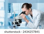 young scientist work with a microscope in modern lab.