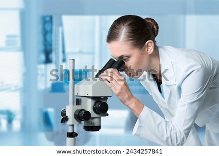 young scientist work with a microscope in modern lab.