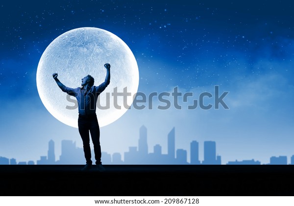 Young screaming man at night with big full\
moon at background