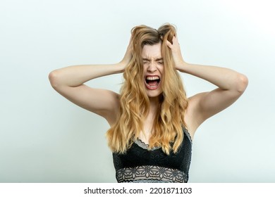 Young Screaming Woman Touches Her Head. Crying Girl Yell. Portrait Of Woman Girl Feeling Pain, Headache, Isolated On Light Background. Stress And Depression, Allergy Or Illness Concept