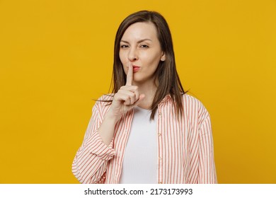 Young Secret Caucasian Woman She 30s Wears Striped Shirt White T-shirt Say Hush Be Quiet With Finger On Lips Shhh Gesture Isolated On Plain Yellow Background Studio Portrait. People Lifestyle Concept