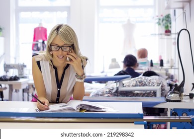 Young self employed woman taking customer orders by phone