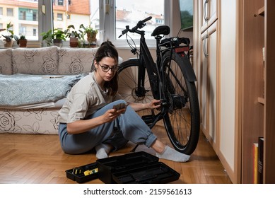 Young Self Learned Woman Or Girl Mechanic Fixing And Repairing Her Bicycle At Her Home. Female Repair Chain On Rear Wheel Before She Start To Ride A Bike On Nice Sunny Weather. 