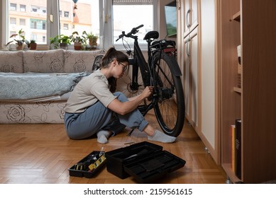 Young Self Learned Woman Or Girl Mechanic Fixing And Repairing Her Bicycle At Her Home. Female Repair Chain On Rear Wheel Before She Start To Ride A Bike On Nice Sunny Weather. 