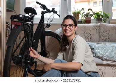 Young Self Learned Woman Or Girl Mechanic Fixing And Repairing Her Bicycle At Her Home. Female Repair Chain On Rear Wheel Before She Start To Ride A Bike On Nice Sunny Weather.