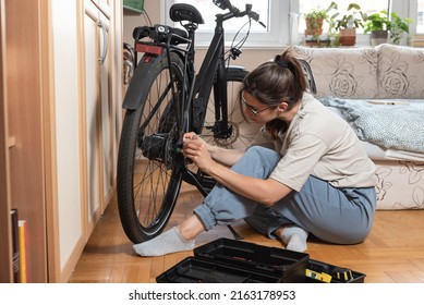 Young Self Learned Woman Or Girl Mechanic Fixing And Repairing Her Bicycle At Her Home. Female Repair Chain On Rear Wheel Before She Start To Ride A Bike On Nice Sunny Weather.