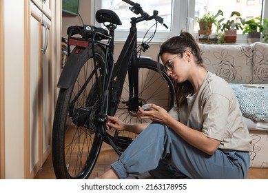 Young Self Learned Woman Or Girl Mechanic Fixing And Repairing Her Bicycle At Her Home. Female Repair Chain On Rear Wheel Before She Start To Ride A Bike On Nice Sunny Weather.