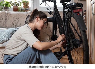 Young Self Learned Woman Or Girl Mechanic Fixing And Repairing Her Bicycle At Her Home. Female Repair Chain On Rear Wheel Before She Start To Ride A Bike On Nice Sunny Weather.