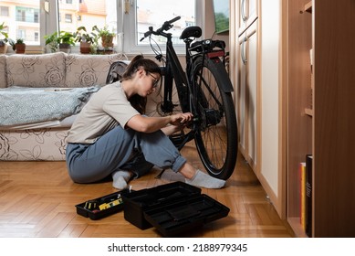 Young Self Learned Woman Or Girl Mechanic Fixing And Repairing Her Bicycle At Her Home. Female Repair Chain On Rear Wheel Before She Start To Ride A Bike On Nice Sunny Weather.