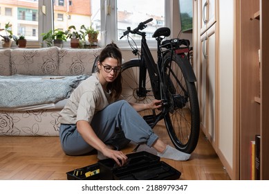 Young Self Learned Woman Or Girl Mechanic Fixing And Repairing Her Bicycle At Her Home. Female Repair Chain On Rear Wheel Before She Start To Ride A Bike On Nice Sunny Weather.