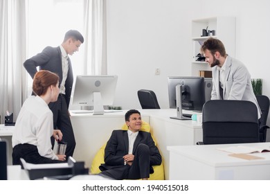 young self-made businessmen in the office discuss a new startup, share business ideas and directions of the company's development. - Shutterstock ID 1940515018